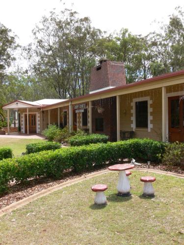 a building with three stools in front of it at Copper Country Motor Inn in Nanango