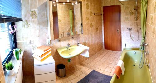 a bathroom with a sink and a bath tub at Ferienwohnung am Parkwohnstift in Bad Kissingen