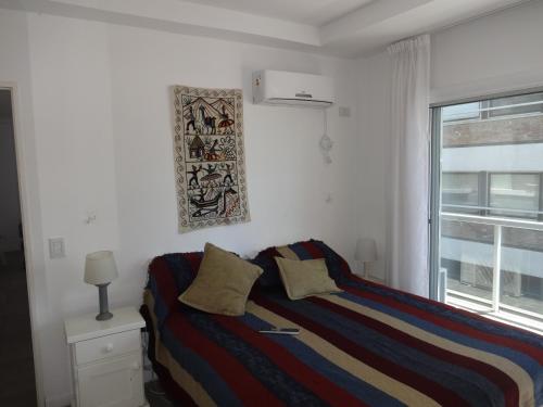 1 dormitorio con 1 cama con 2 almohadas y ventana en Paseo Victorica al 700 en Tigre