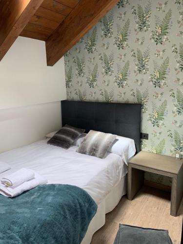 a bedroom with a large white bed and a table at Tuca del Mont in Benasque