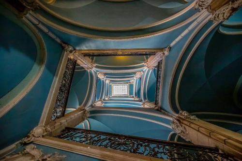 a spiral staircase in a building with blue ceilings at Deluxe Ploech in Rijeka