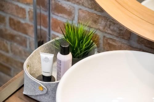 a basket with two bottles of soap and a toilet at Deluxe Ploech in Rijeka