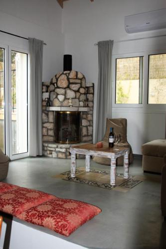 a living room with a table and a stone fireplace at Villa Pilali in Kefallonia
