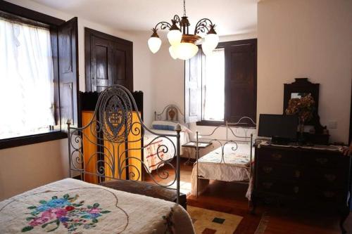 1 dormitorio con cama y lámpara de araña en Quinta de Vila Verde- Paixão Ancestral, Turismo Rural, en Marco de Canaveses
