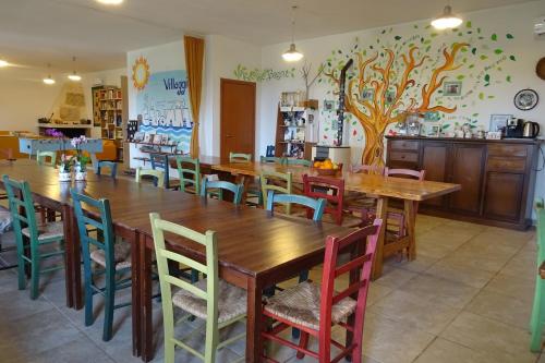 una sala da pranzo con un grande tavolo in legno e sedie di B&B Casa per ferie VillaggioCarovana a Castiadas