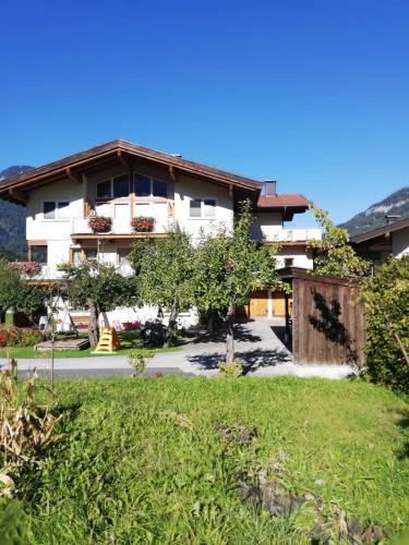 a house in the middle of a green yard at Appartement Nani in Söll