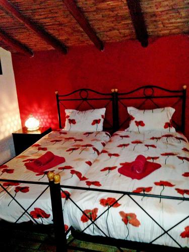 a red bedroom with a bed with red flowers on it at Casa Kamari in Estói