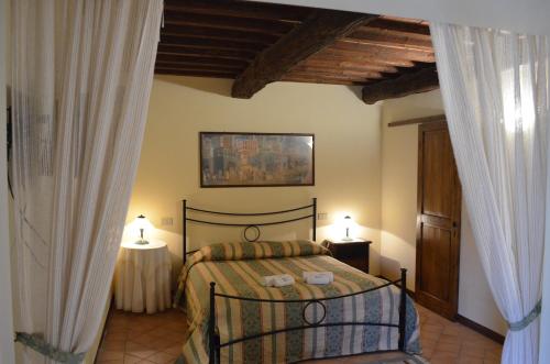 1 dormitorio con 1 cama con 2 mesas y 2 lámparas en Agriturismo Poderino en San Quirico dʼOrcia