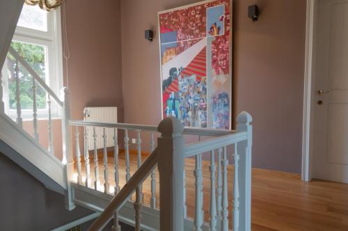 a staircase in a home with a painting on the wall at Prachtig herenhuis uit 1925 in Nijlen