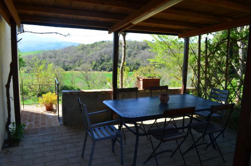 a table and chairs on a patio with a view at Agriturismo Poderino in San Quirico dʼOrcia