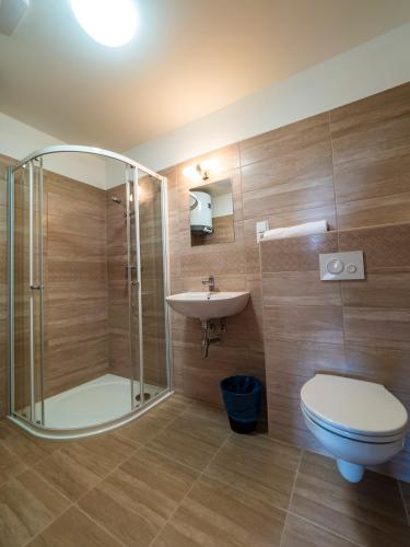 a bathroom with a shower and a toilet and a sink at Penzion Pastouška s pohostinstvím in Moravský Krumlov