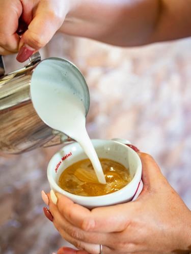 a woman is pouring milk into a cup of soup at Penzion Pastouška s pohostinstvím in Moravský Krumlov