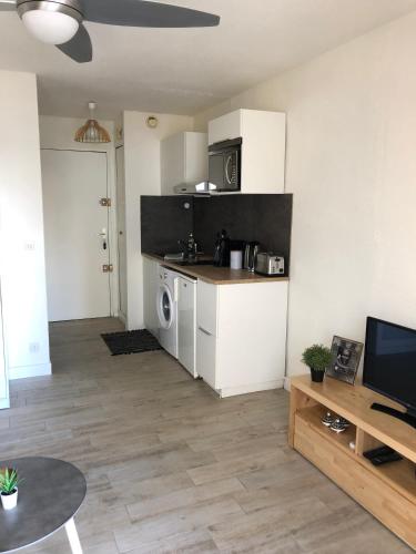 Il comprend un salon avec une cuisine et une table avec une télévision. dans l'établissement Studio l'Eldorado, à Palavas-les-Flots