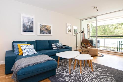 a living room with a blue couch and a table at Acqua de Cascais in Cascais