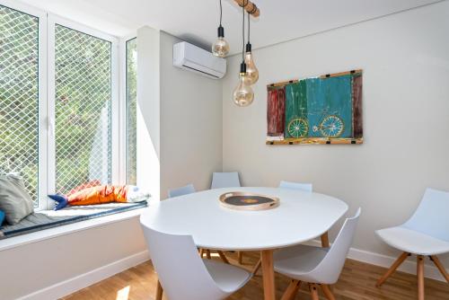 a white dining room with a white table and chairs at Acqua de Cascais in Cascais