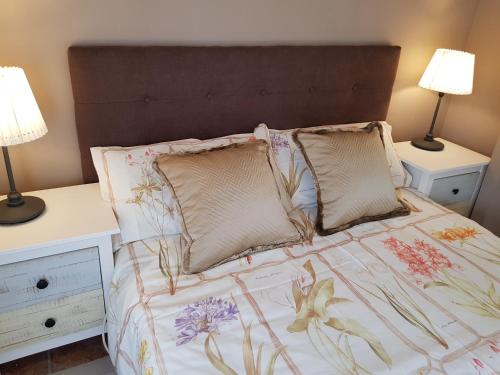 a bedroom with a bed with two night stands and two lamps at Casita Las Melosillas in Casabermeja