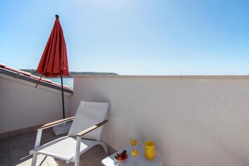 a balcony with a table and chairs and an umbrella at Apartments CAPE Deluxe in Rtina