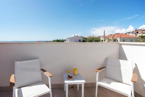two chairs and a table on a balcony at Apartments CAPE Deluxe in Rtina