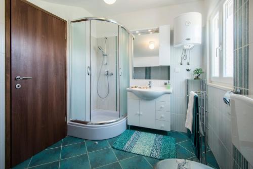 a bathroom with a shower and a sink at Apartments CAPE Deluxe in Rtina