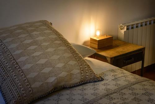 a bedroom with a bed and a night stand with a candle at Cal Menescal in Les Olives