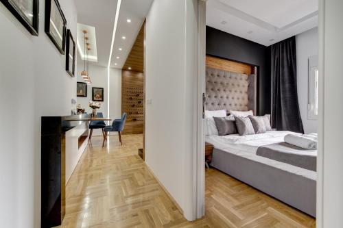 a bedroom with a large bed and a desk at CENTAR President in Arandjelovac