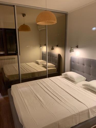 a bedroom with two beds and a large mirror at Floreasca Apartment Bach in Bucharest