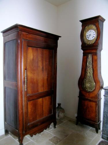une horloge grand-père à côté d'un meuble en bois dans l'établissement LE MARAIS 3 Bedrooms APT, à Paris