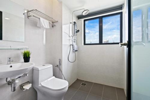 a bathroom with a toilet and a sink and a window at Rica Hotel Usj in Subang Jaya