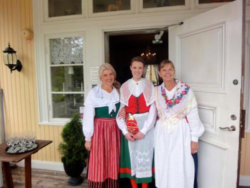 three women are standing in front of a door at Långshyttans Brukshotell in Långshyttan
