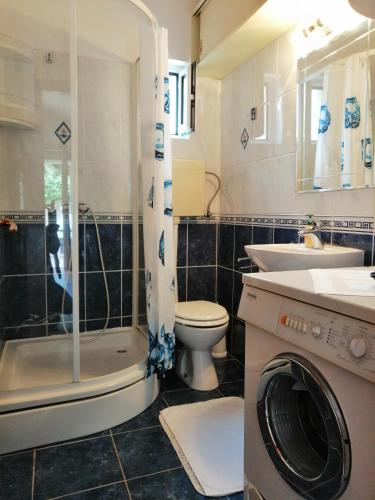 a bathroom with a toilet and a sink and a washing machine at Apartment Džoni in Split