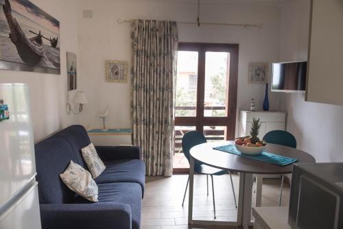 a living room with a blue couch and a table at Casa Fabio in Stintino