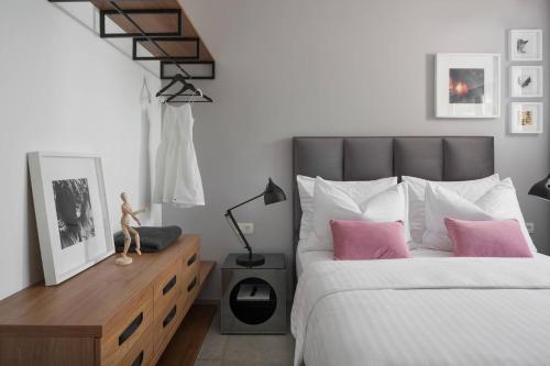 a bedroom with a large bed with pink pillows at Olive Hill House - ground floor in Slatine
