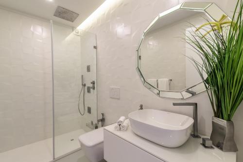a white bathroom with a sink and a mirror at Cascais Center Luxury Beach Apartment in Cascais