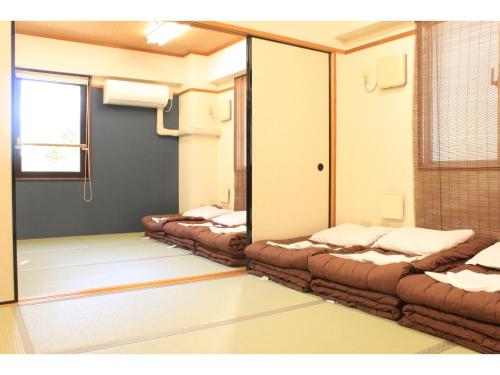 T and K Hostel Kobe Sannomiya East tesisinde bir odada yatak veya yataklar
