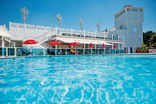 a large swimming pool in front of a building at Rockley Park - Coral in Poole