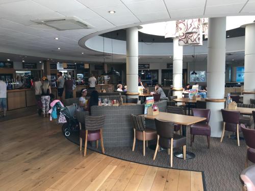 a restaurant with tables and chairs and people eating in it at Rockley Park - Coral in Poole