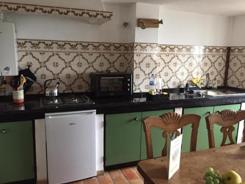 a kitchen with green cabinets and a counter top at Casa Kamari in Estói