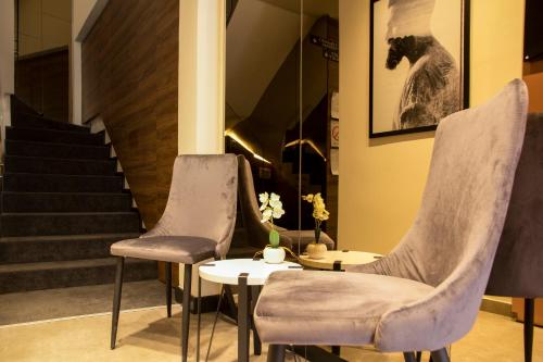 two chairs and a table in front of a staircase at BOUTIQUE 25h by Eva stay 018 in Niš