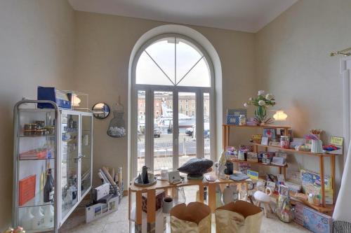 a room with an arched window and a room with a table at Hôtel L'orque Bleue in Sète
