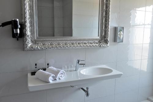
a white sink sitting under a mirror in a bathroom at Hotel La Villa Nice Victor Hugo in Nice
