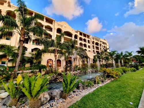 an exterior view of a hotel with palm trees at Landmark by Villas Segovia in Cozumel