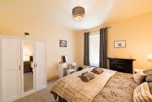 a bedroom with a large bed and a fireplace at STAG City Centre apartment in Inverness