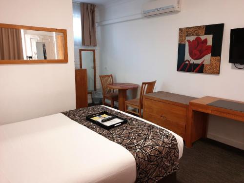 a hotel room with a bed and a desk at Best Western Endeavour Motel in Maitland