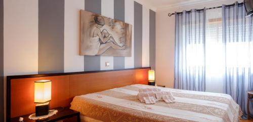 a bedroom with a bed with two towels on it at Rito´s Paradise in Nazaré