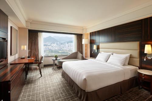 a hotel room with a bed and a desk and a window at Lotte Hotel Busan in Busan