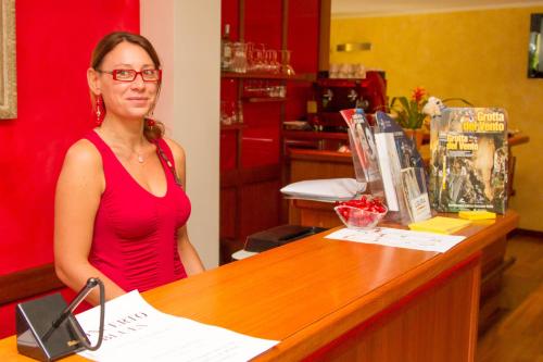 a woman sitting at a counter in a store at Oasi Hotel in Levanto