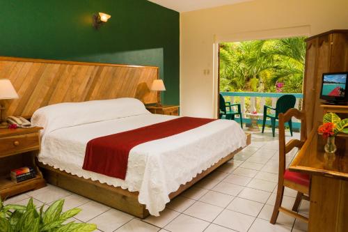 尼格瑞爾的住宿－傳奇海灘度假酒店，一间卧室设有一张床和一个滑动玻璃门