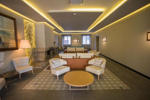 a living room with a couch and chairs and a table at Hotel Brazão in Vila do Conde