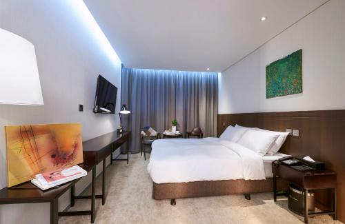 a hotel room with a large bed and a television at Hotel Mfelice in Seoul