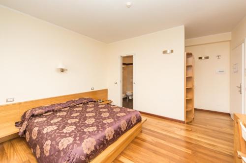a bedroom with a bed and a wooden floor at Oasi Hotel in Levanto